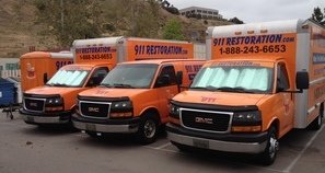 Mold and Water Damage Restoration Vans And Trucks At Job Site